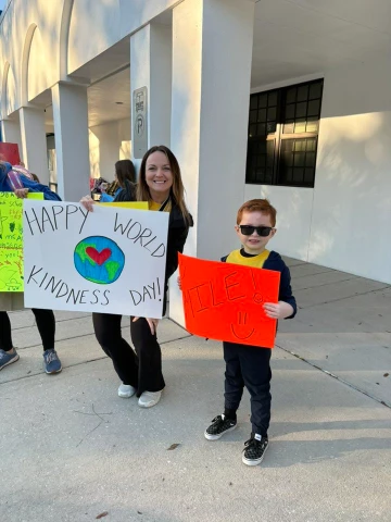Teacher and student holding signs for kindness day